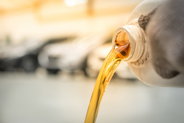 pouring-engine-oil-into-engine-room-gold-oil-during-car-oil-change-repair-shop-service-center-interior-car-care-center_140555-338